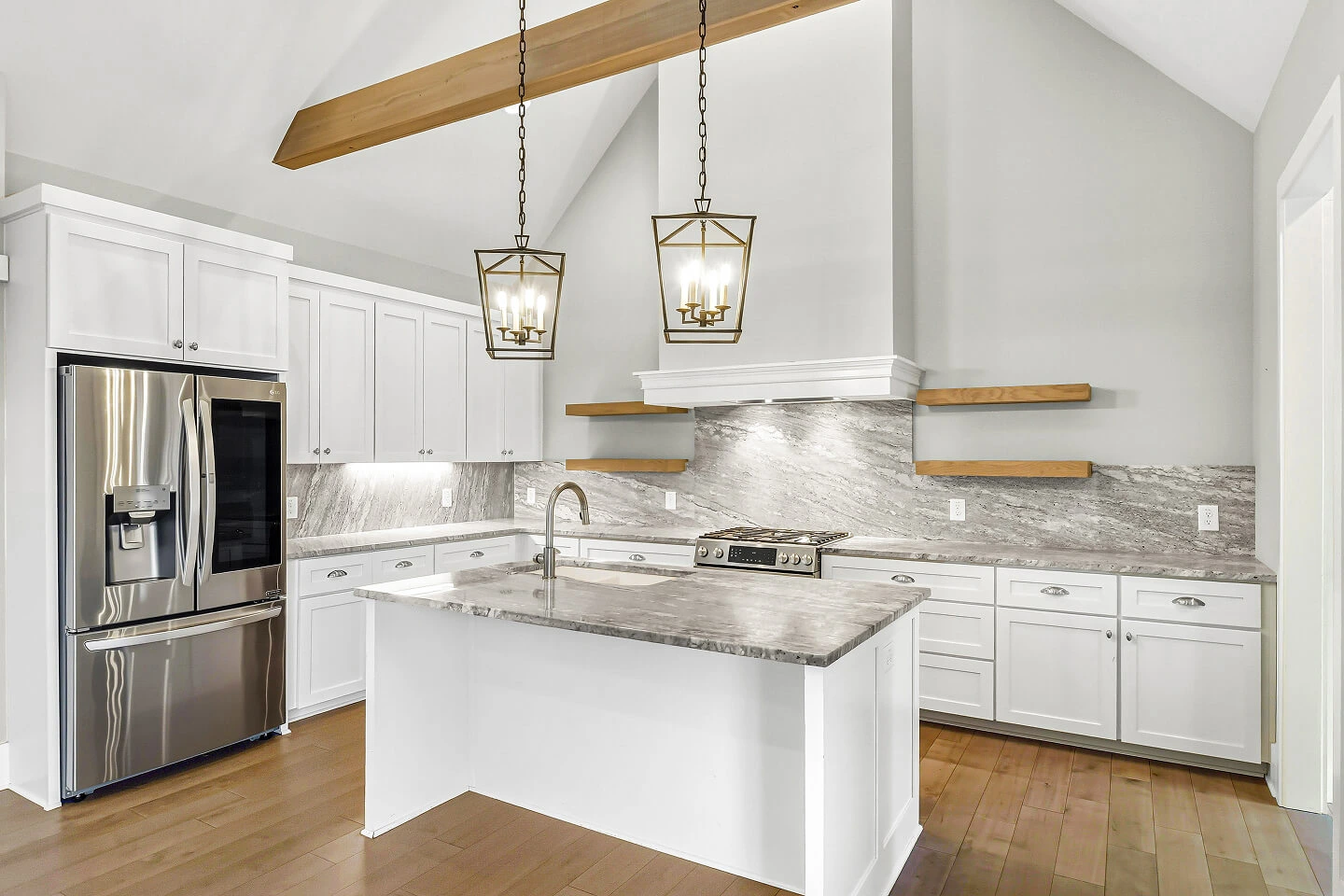 White modern kitchen with marble countertops and pendant lighting